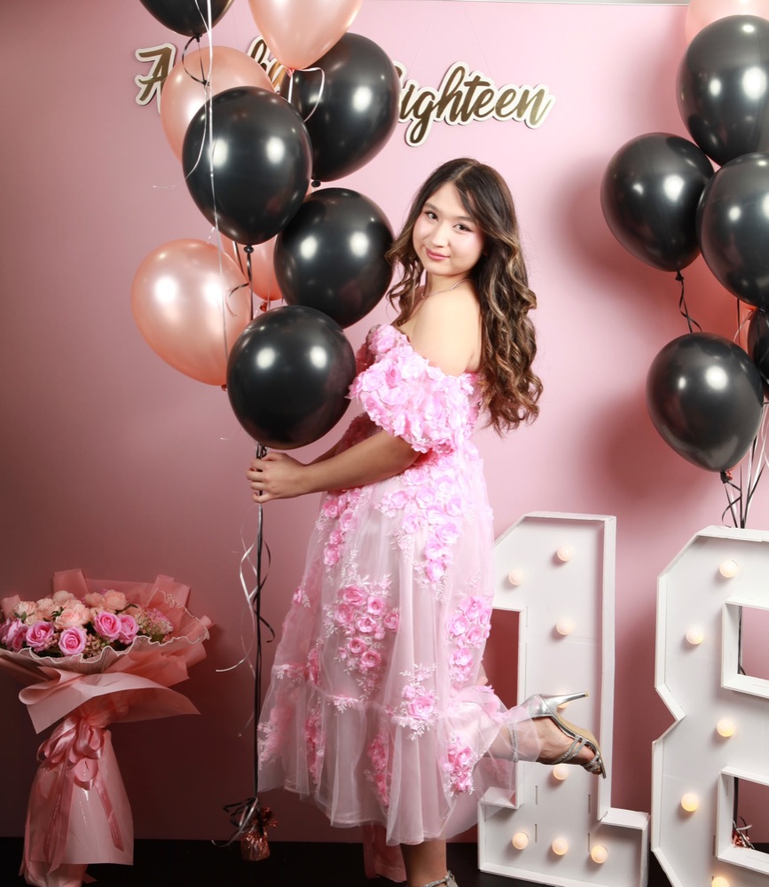 Guest posing with balloons at a Lazuro event photo stage